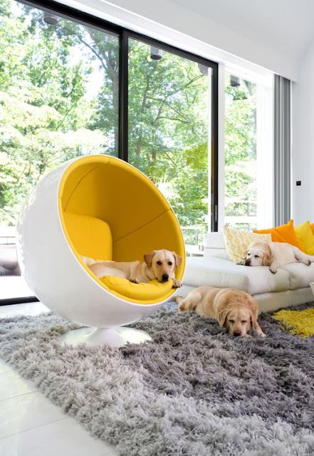 Sala blanca y muy iluminada con una de las sillas icónicas más divertidas en color amarillo La silla Ball