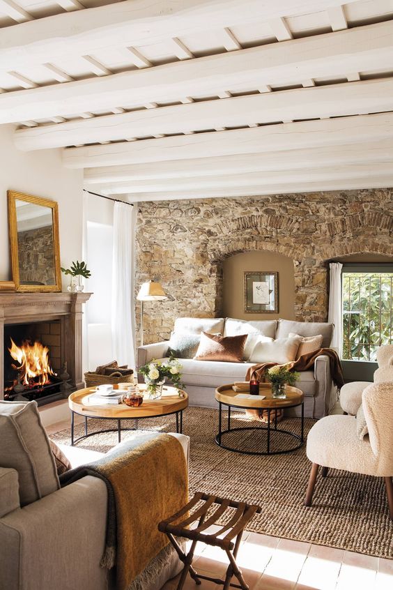 Sala con vigas de madera y muros de piedra, estilo rústico.