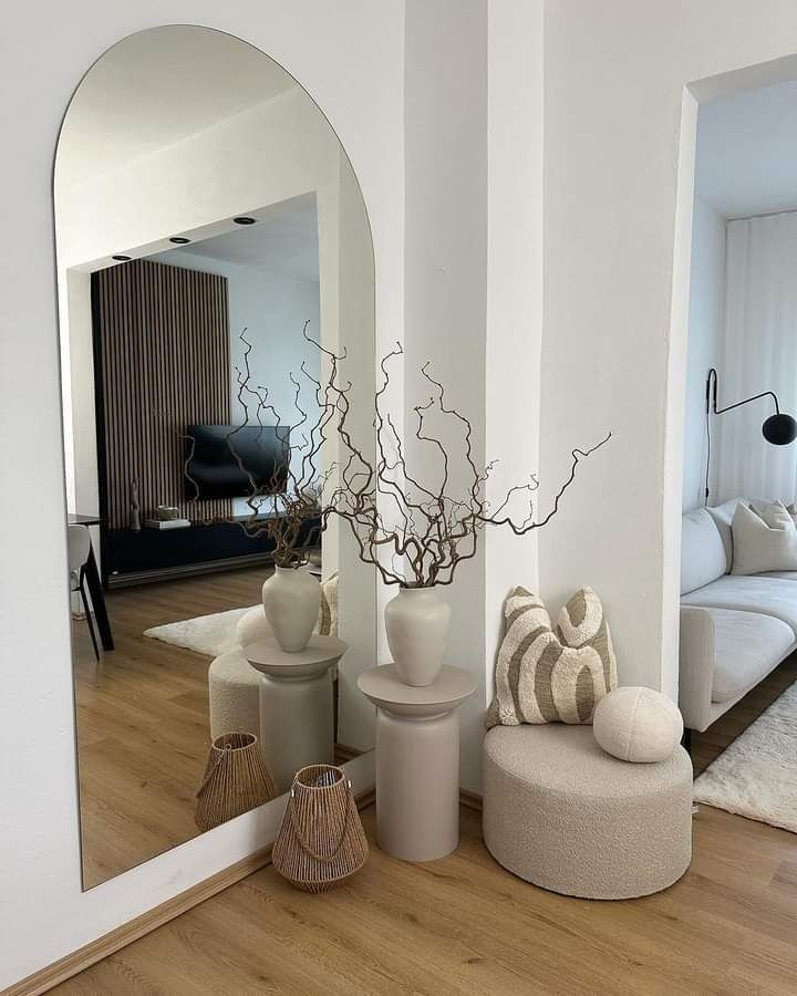 Decoración interior estilo contemporáneo con muebles en líneas limpias y un espejo de gran formato en forma de arco